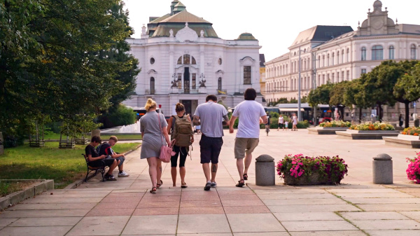 Historie ožívá – když tým hraje hlavní roli přímo na jevišti města Účastníci hry stojí před Městským divadlem v Ústí nad Labem s tabletem v ruce